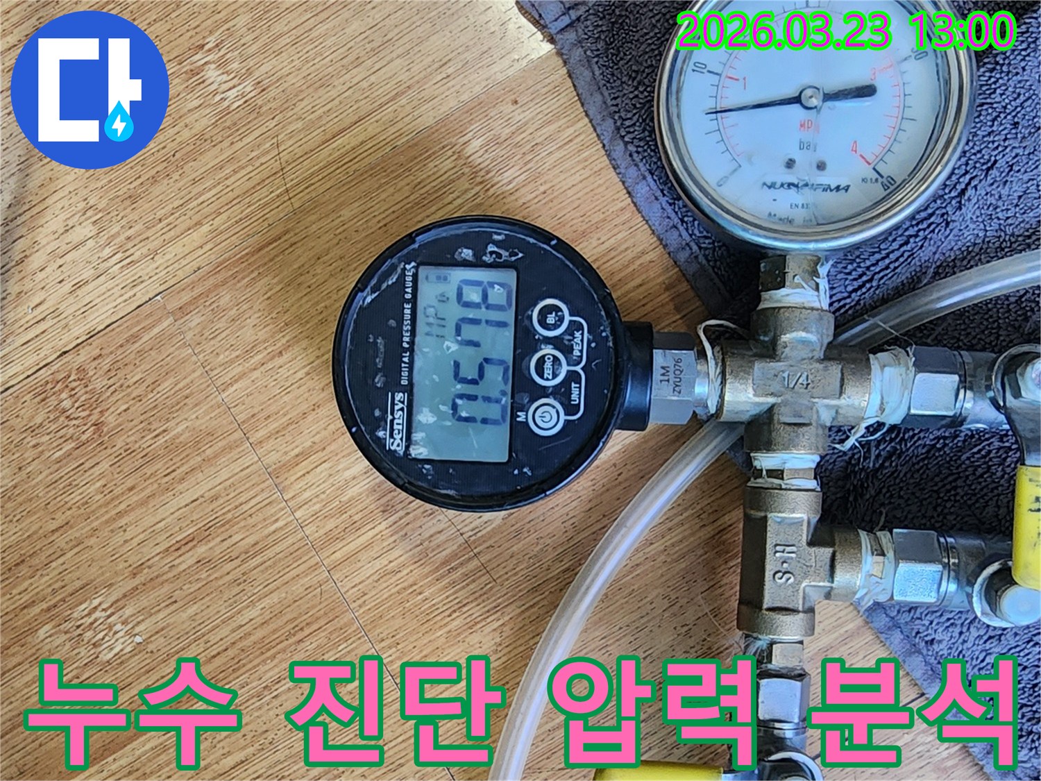 누수 진단을 위해-배관에 연결된 디지털 압력계가 현재 압력 수치를 정확히 보여주며-전문가가 이를 면밀히 분석하고 있습니다.