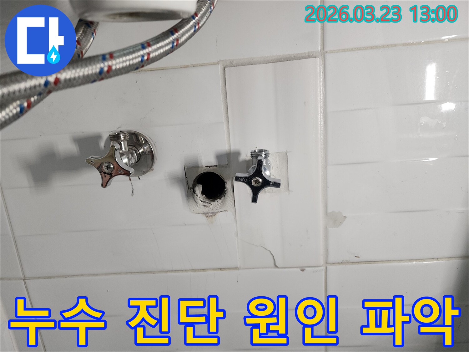 하얀색 타일 벽면의-수도 배관 연결 부위에서-누수가 확인되어-타일을 제거하고-배관을 점검하는-누수 현장입니다.