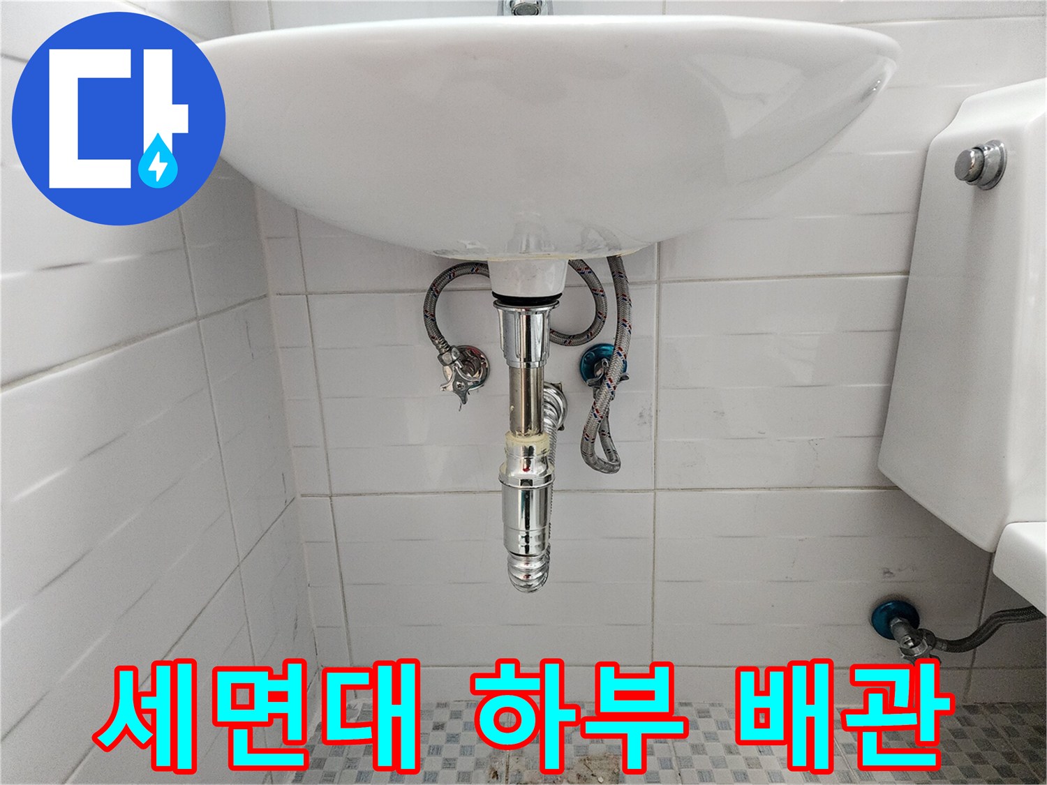 화장실 세면대 아래쪽의 밸브와 연결 호스 상태를 보여주는 사진입니다.