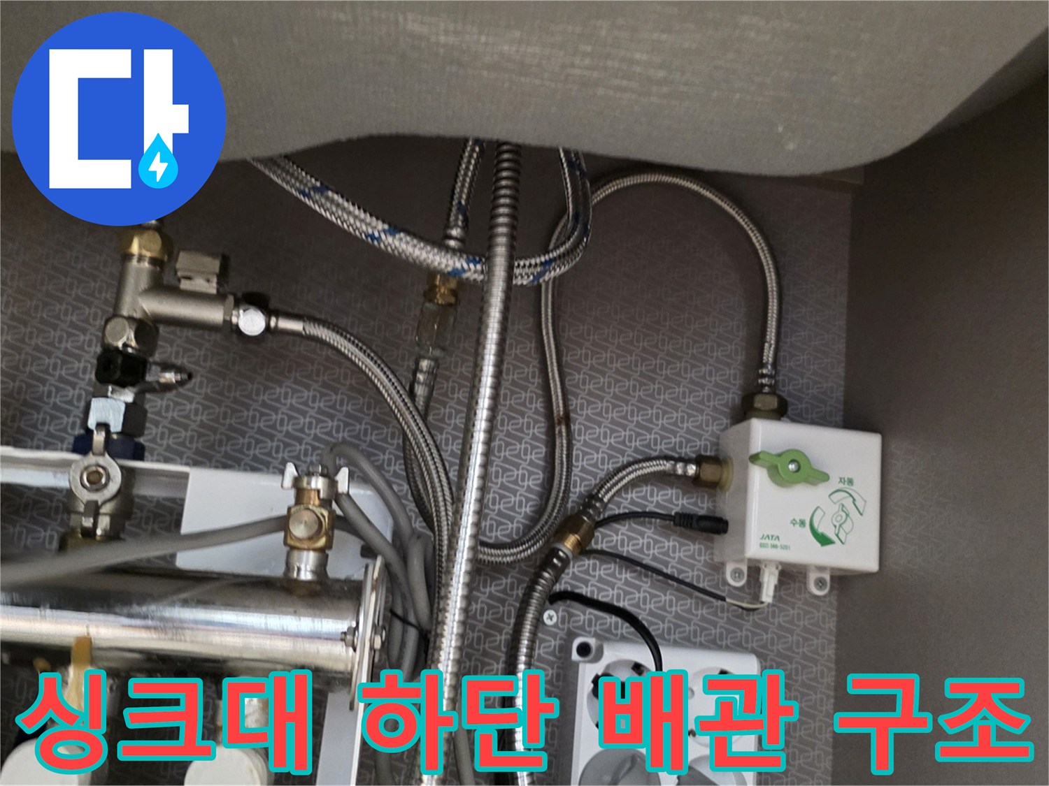 싱크대 아래쪽 금속 분배기와 연결된 호스들의 상세 모습