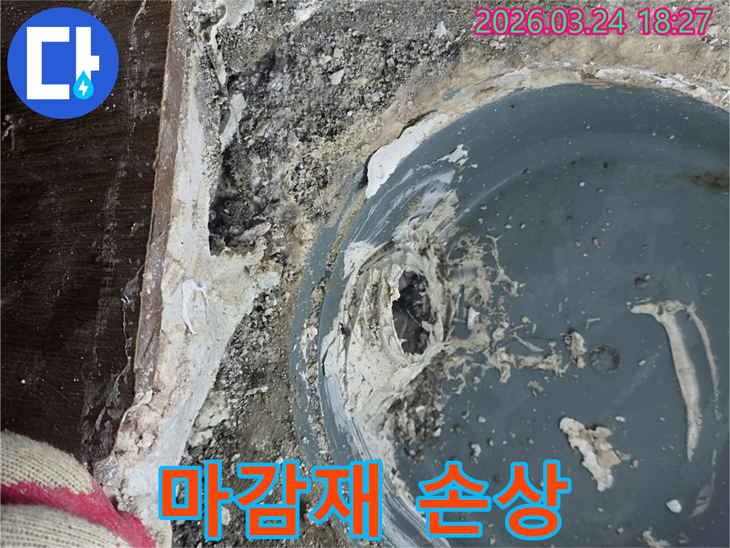 배수구 주변의 마감재가 손상되어 누수가 발생한 현장을 탐지 중인 사진입니다.