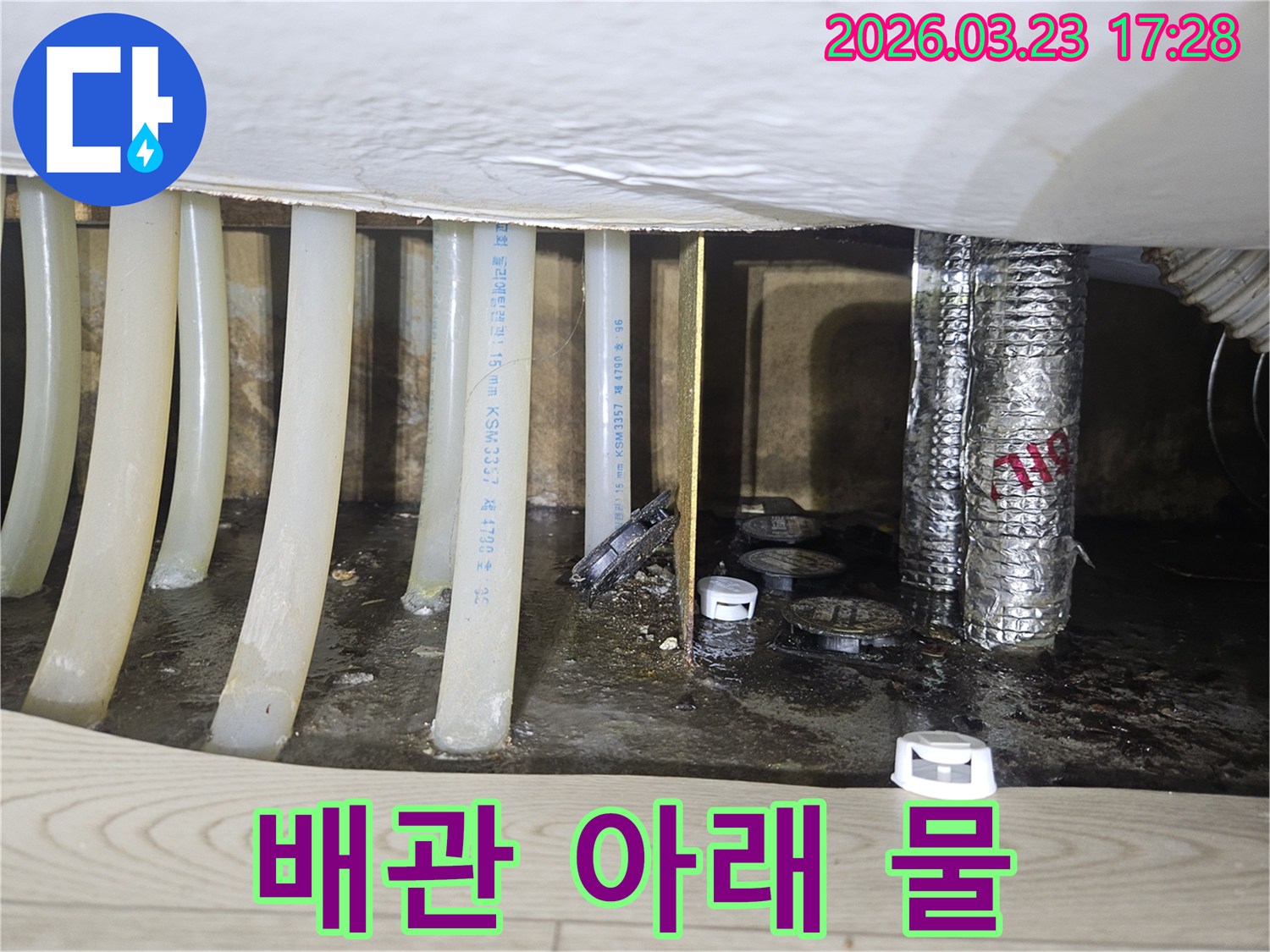 배관 아래에-물이 고여있는-누수 현장의-심각성을 보여주는-현장 사진입니다.