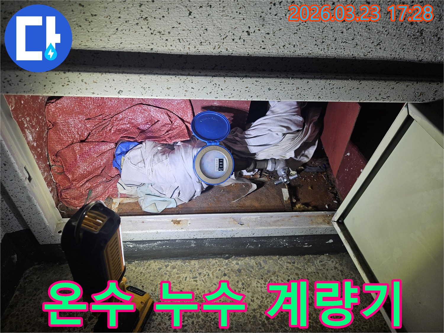 수도 계량기 덮개를 열고 내부 상태를 점검하며 누수 지점을 파악하는 작업