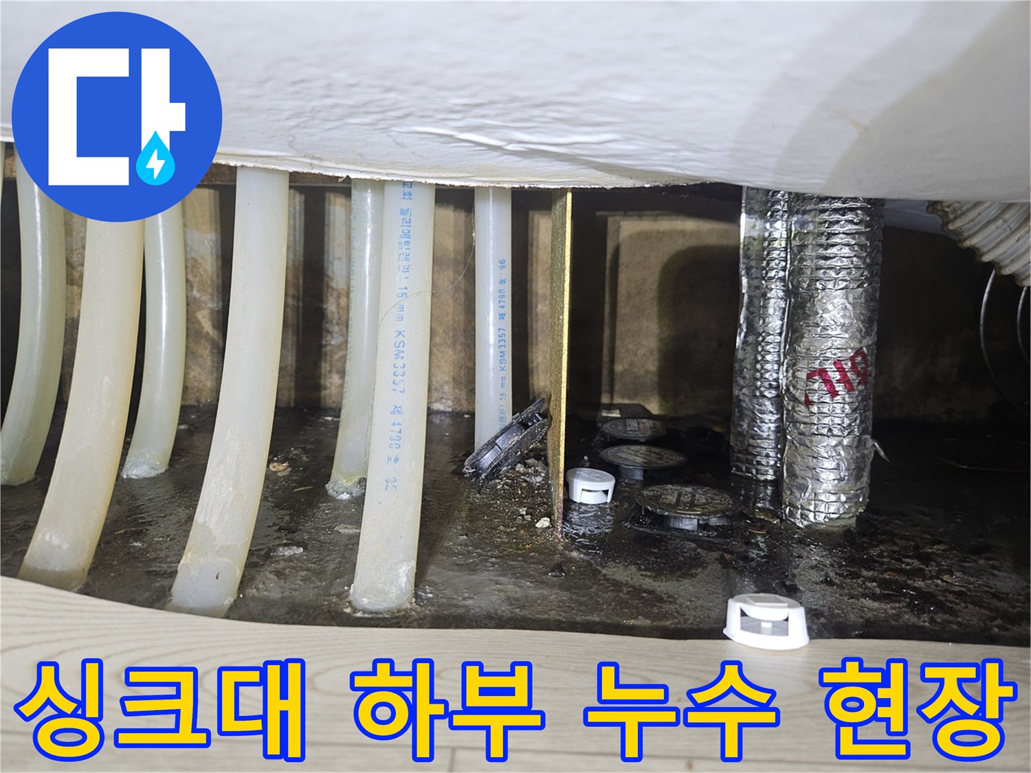 싱크대 밑 배관 주변의 젖은 바닥과 습기 찬 환경 사진