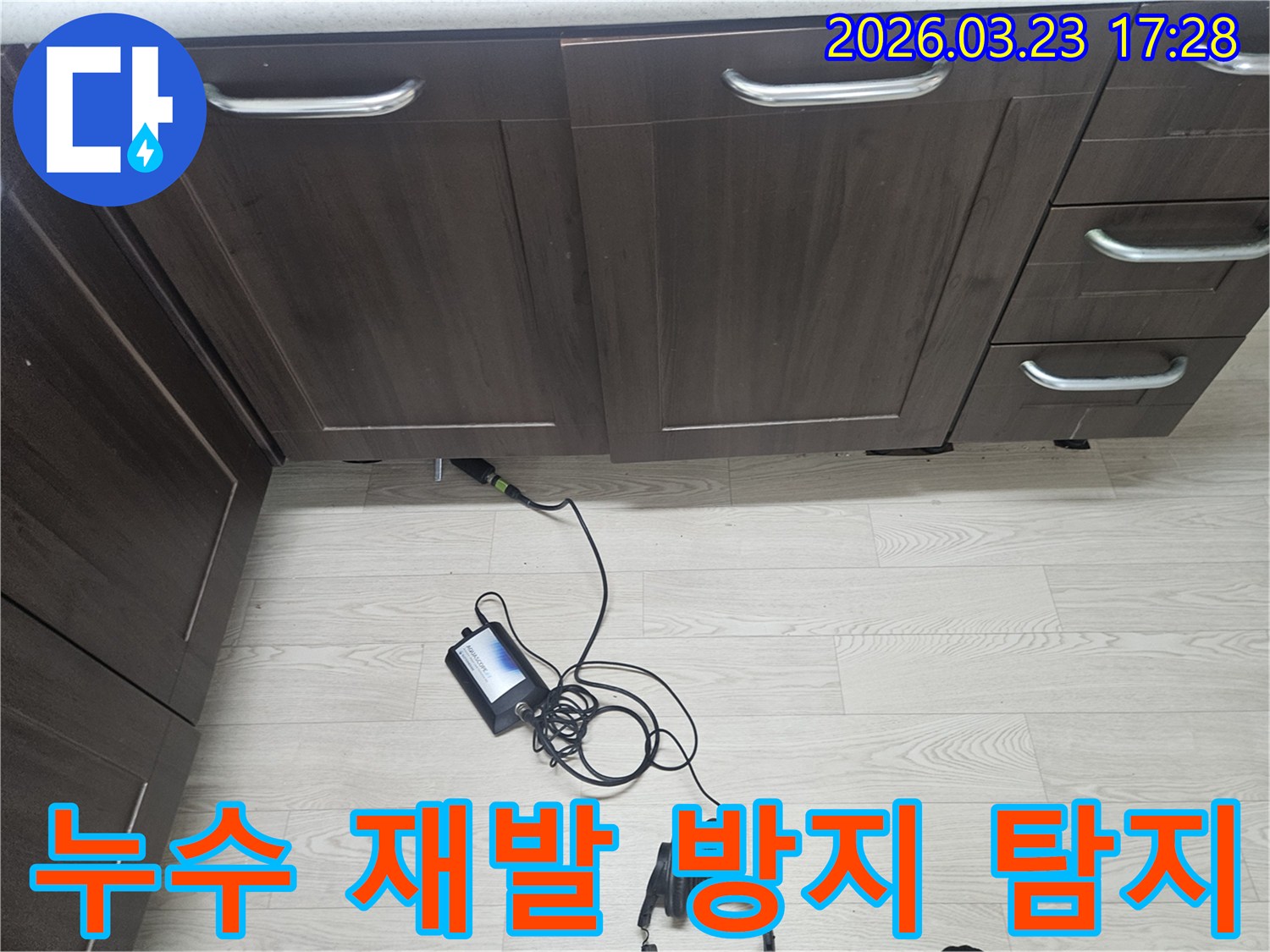 용인 기흥구의 주방 싱크대 하부에서-누수 재발을 막기 위한 정밀한 탐지를 위해-청음식 탐지 장비로-꼼꼼하게 검사하는 엔지니어의 모습