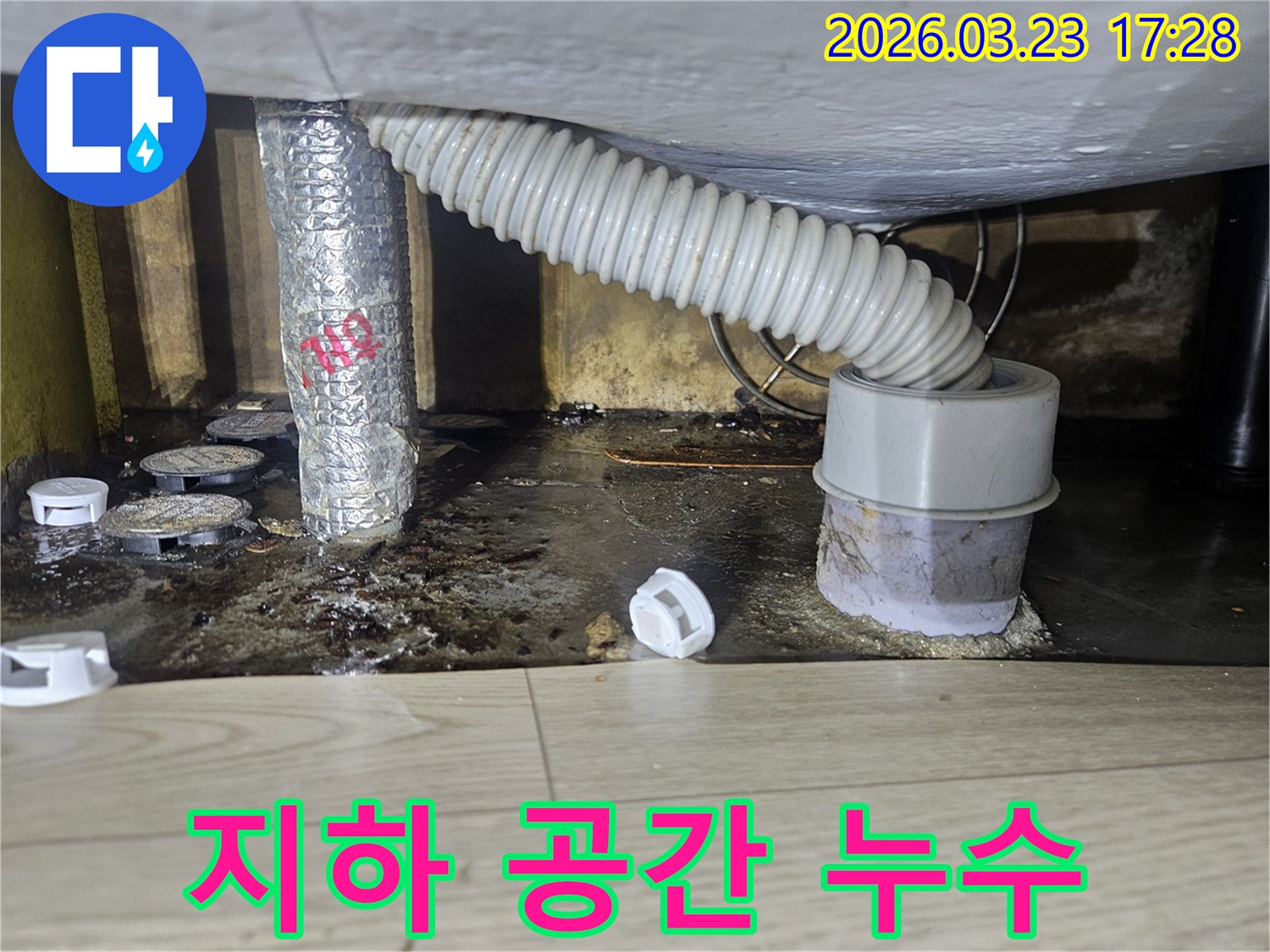 이 이미지는 지하 공간에서 발생한 누수로 인해 바닥이 젖고 오염된 현장을 보여주며-습기 제거와 방수 공사가 시급합니다.