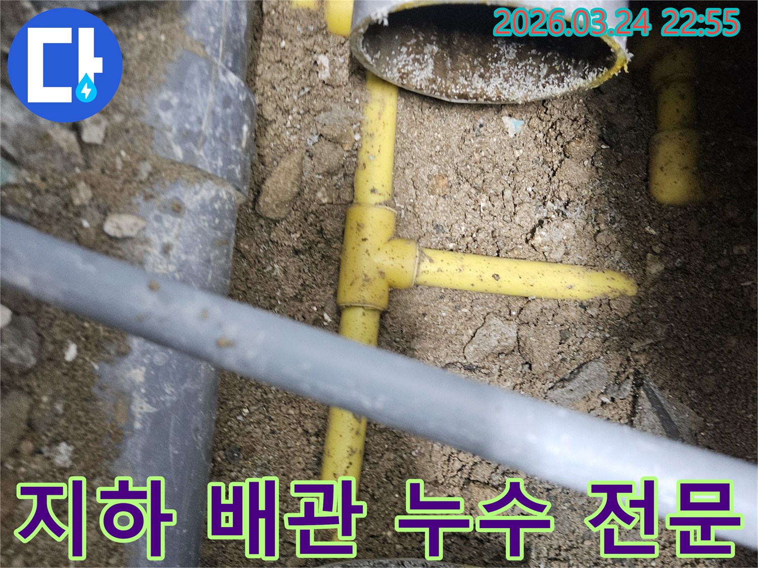 깊이 파헤쳐진 땅속에서-노란색 수도관과-회색 PVC 배관이-복잡하게 연결된-누수 현장의 모습입니다.