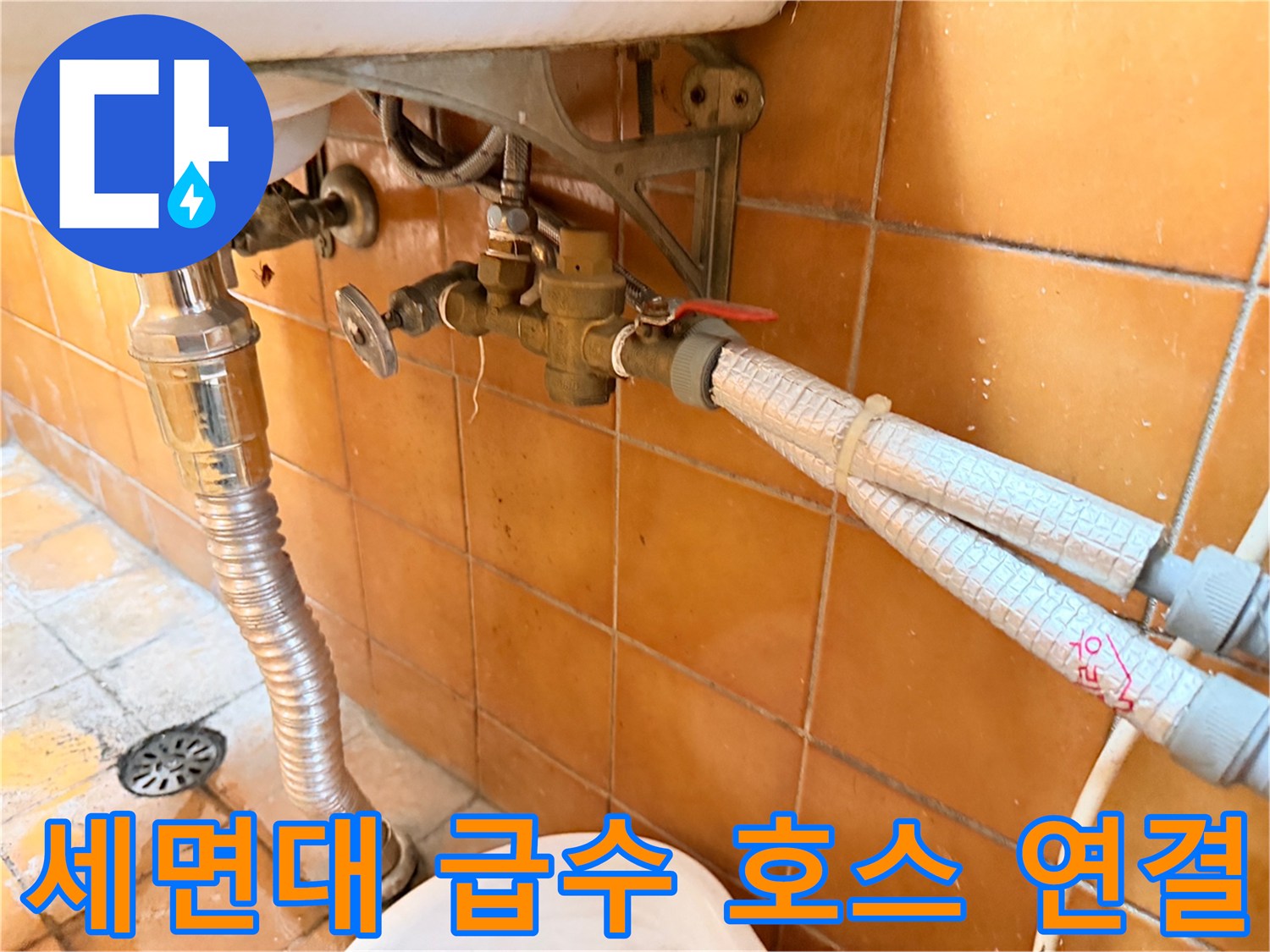 세면대 아래쪽 밸브와 은색 배관의 결합 상태를 보여주는 사진
