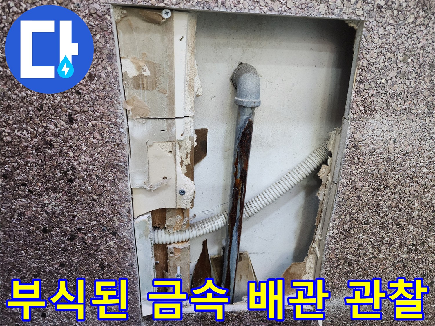 벽면 내부의 부식된 수도관과 흰색 주름 호스 연결 상태