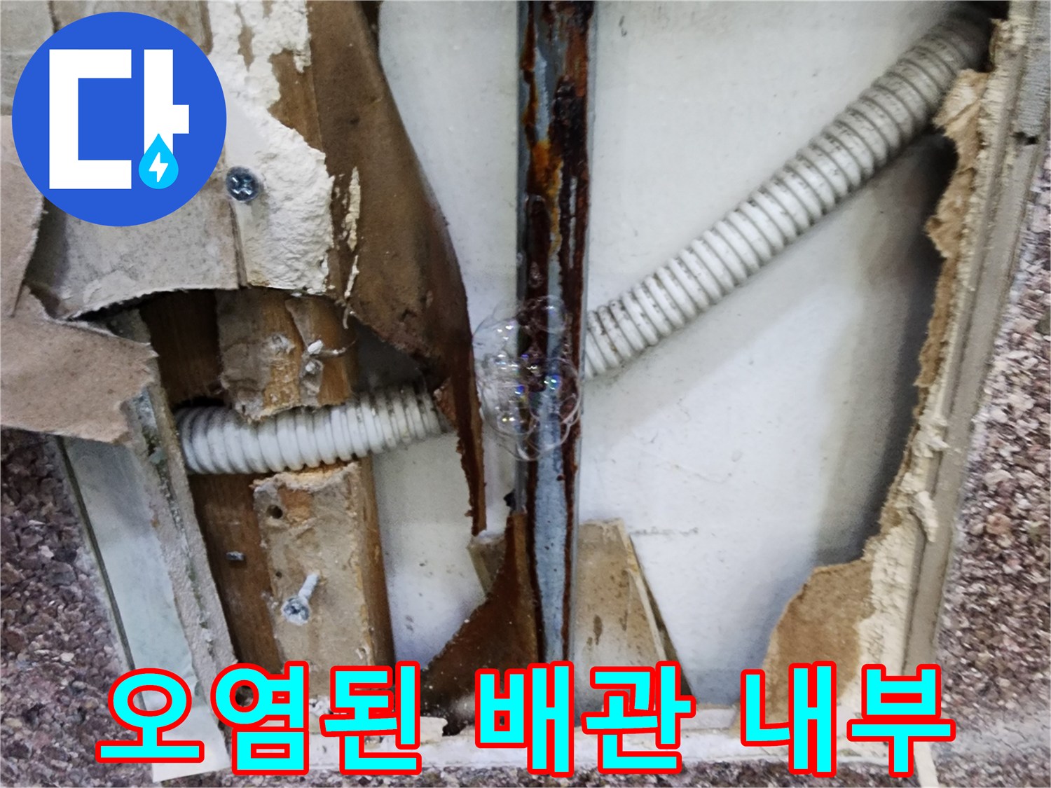 벽면 타공 현장-부식된 금속관과 주름진 배관의 모습