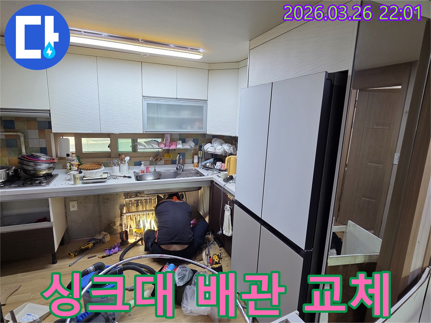 싱크대 하부장에서 발생한 누수를-전문가가 수리하는 모습입니다