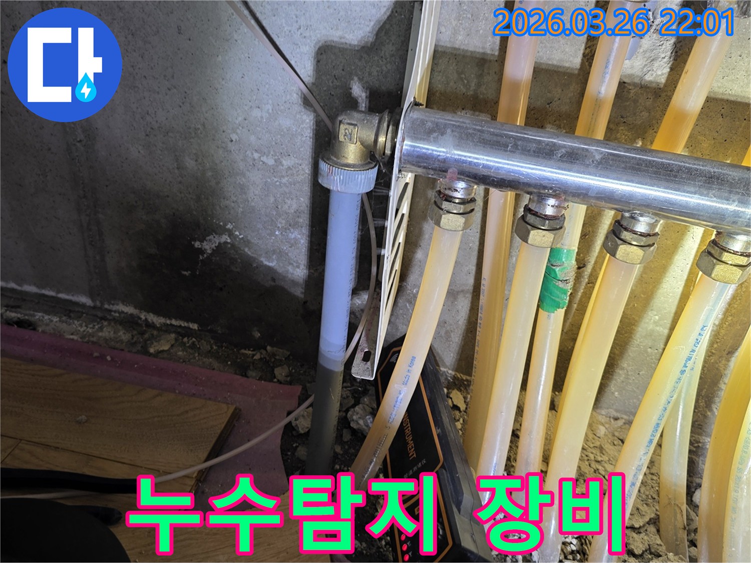이 이미지는-난방 배관 누수-탐지 현장에서-젖은 벽면과-배관-그리고-탐지 장비를-보여줍니다.