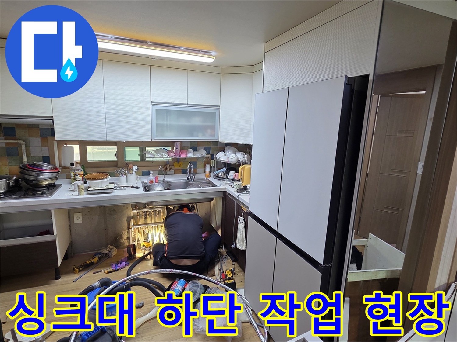 주방 싱크대 하부장에서 누수 지점을 찾기 위해 점검 중인 모습입니다.