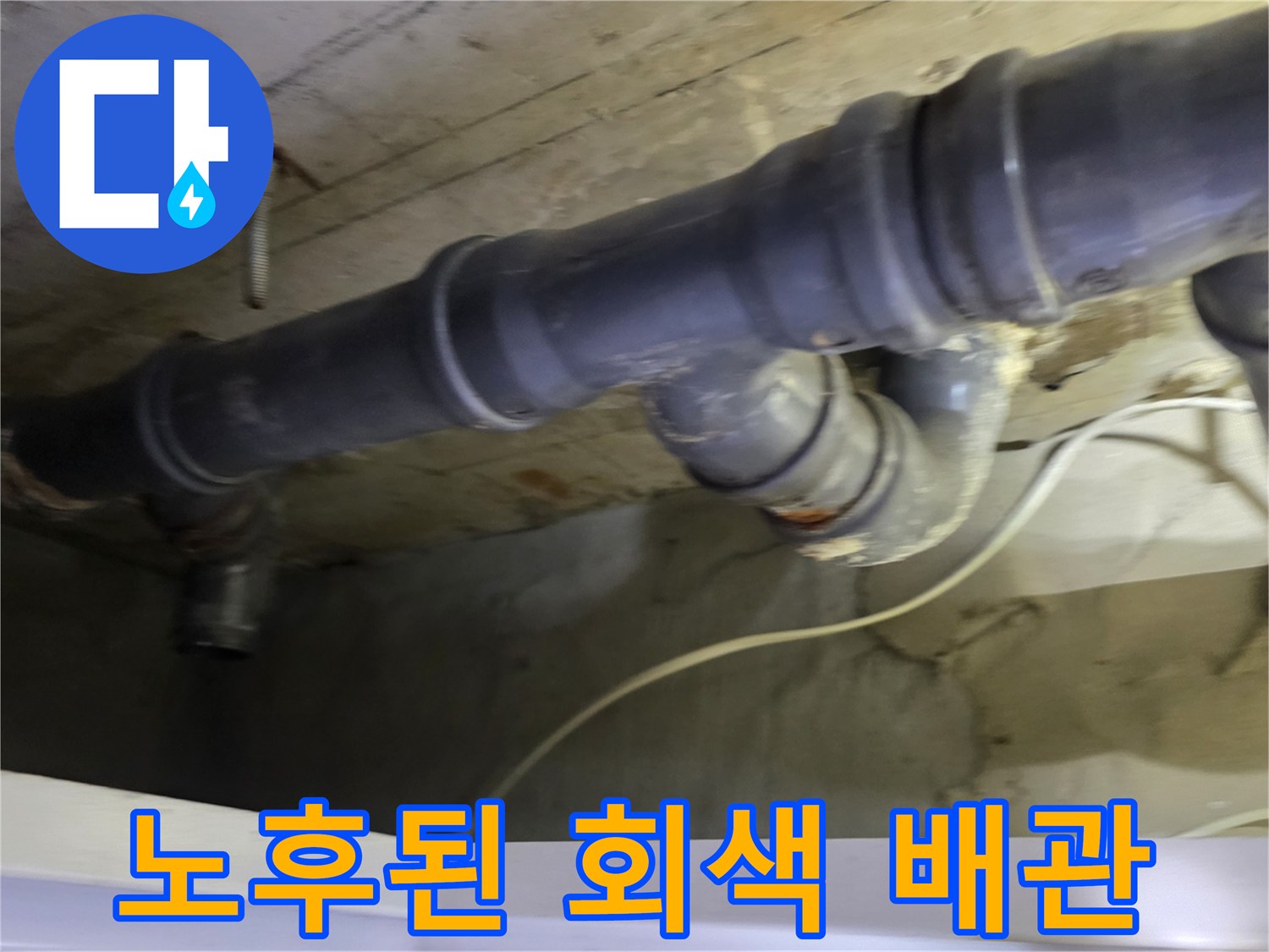 아랫집 화장실 천장에 설치된 낡고 오염된 회색 하수 배관 모습입니다.