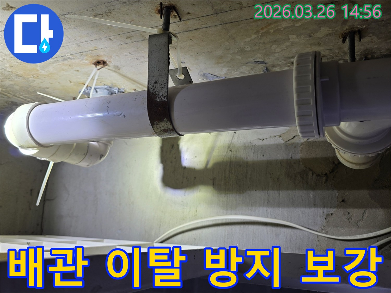 콘크리트 천장에 고정된-하얀색 배관과-오래된 금속 지지대의 모습으로-배관 이탈 방지 보강 공사 현장을 보여줍니다