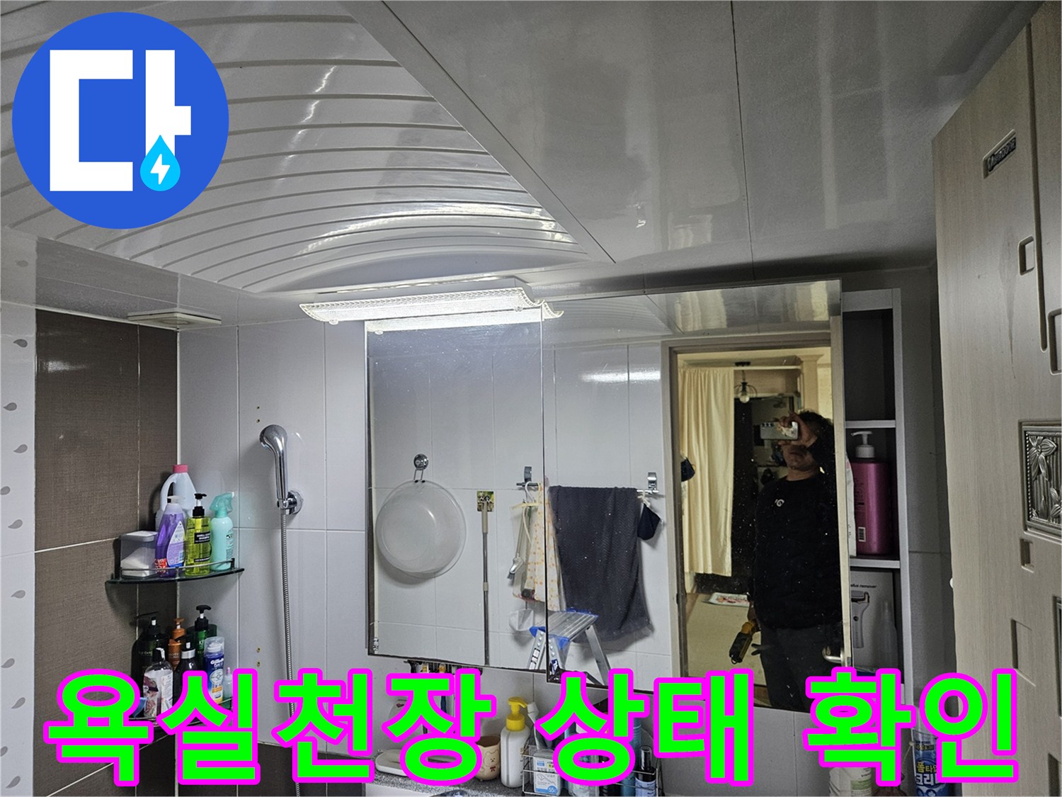 화장실 거울에 비친 천장 마감재와 수납장 모습