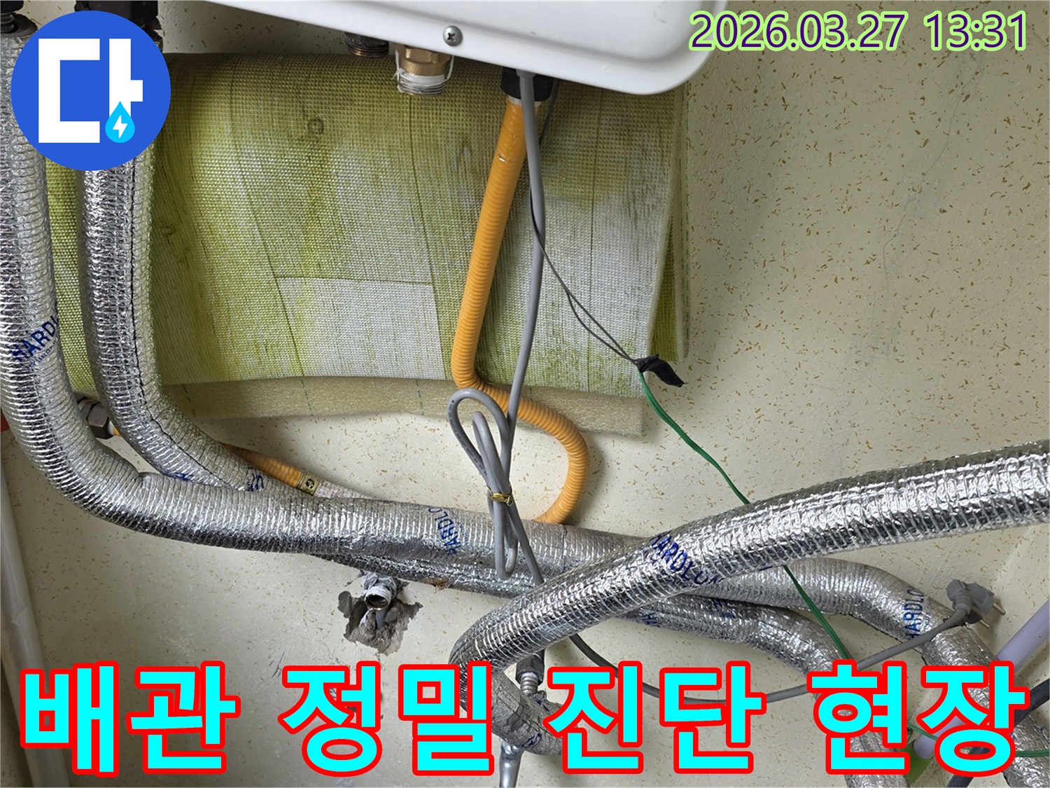 보일러-하단에-위치한-다양한-배관과-전선이-복잡하게-연결된-모습을-보여주며-누수-진단을-위한-현장-조사-중입니다.