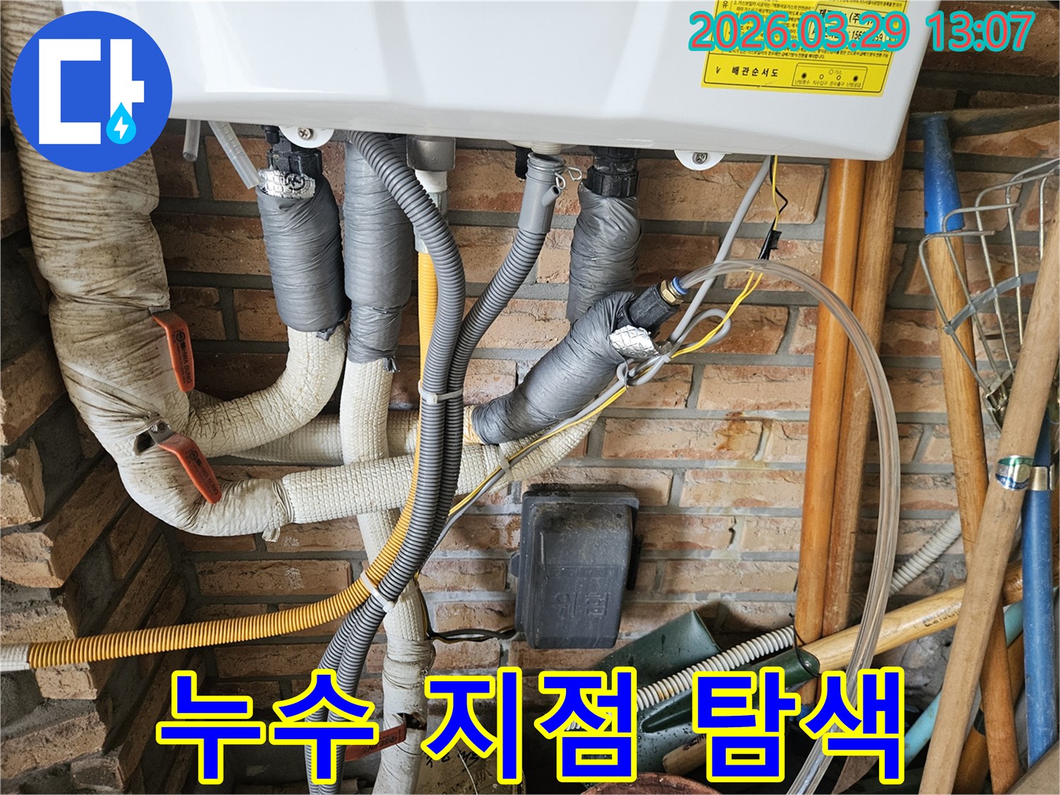 이 이미지는 복잡한 배관들 사이에서-누수 지점을 정확히 찾아내기 위한-전문가의 집중적인 탐색 작업을 보여줍니다.