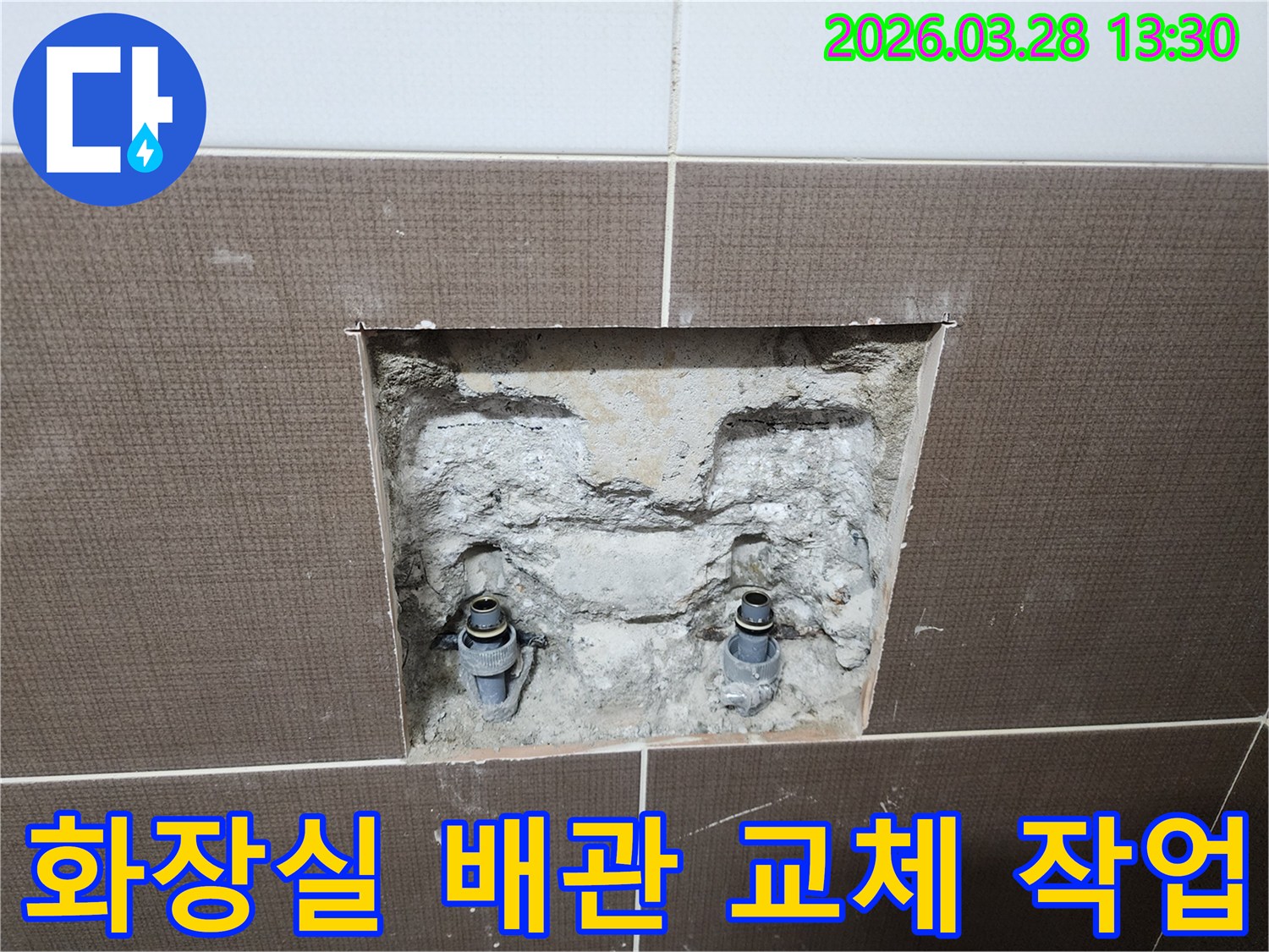 중랑구 중화동 빌라의 화장실 배관 교체 작업을 위해-벽면 타일을 제거하고 노후된 배관을 노출시킨-공사 현장의 초기 단계입니다.