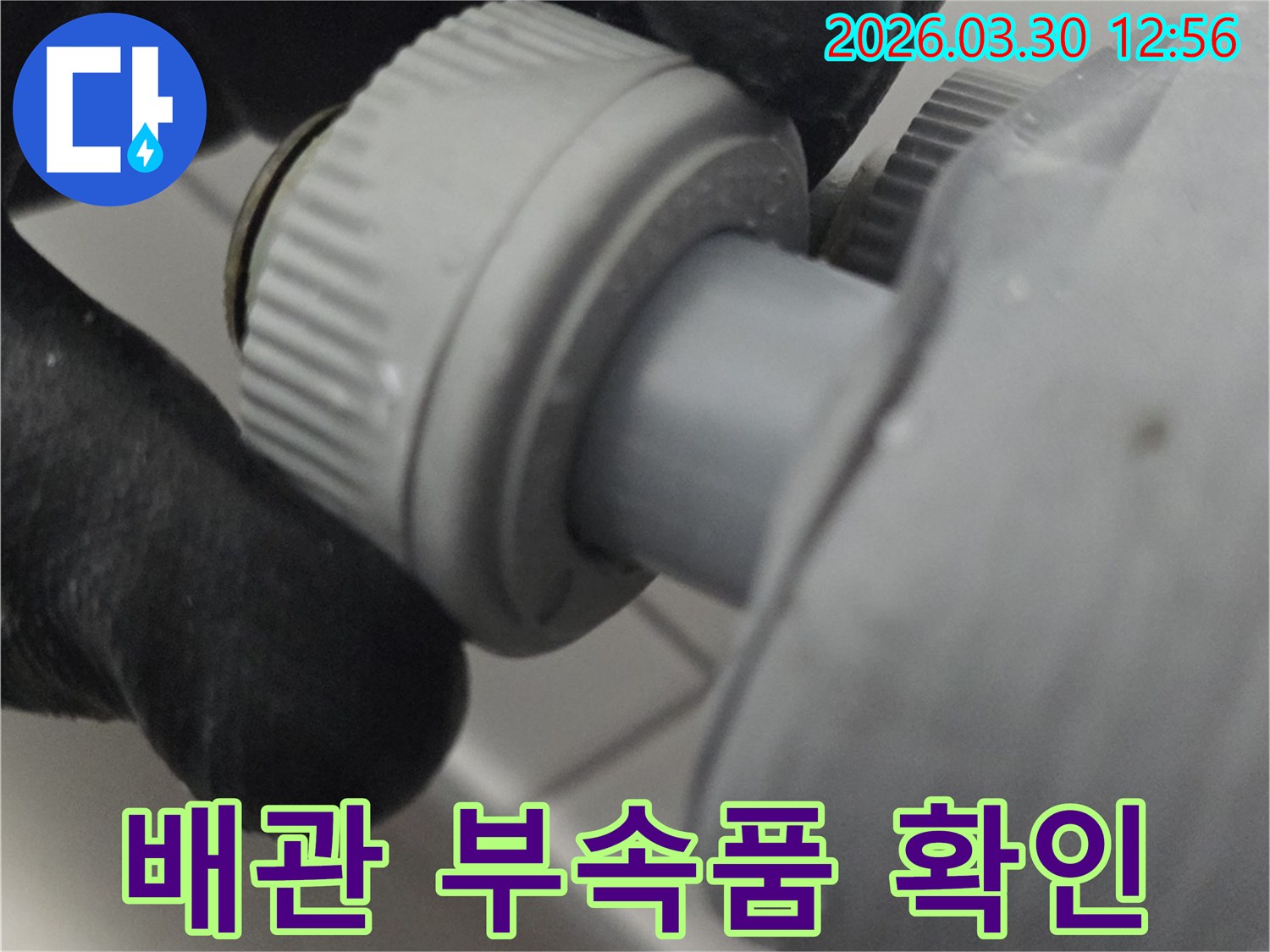 누수 발생 가능성이 높은 배관 부속품의 상태를 육안으로 확인하고 있는 전문가의 모습