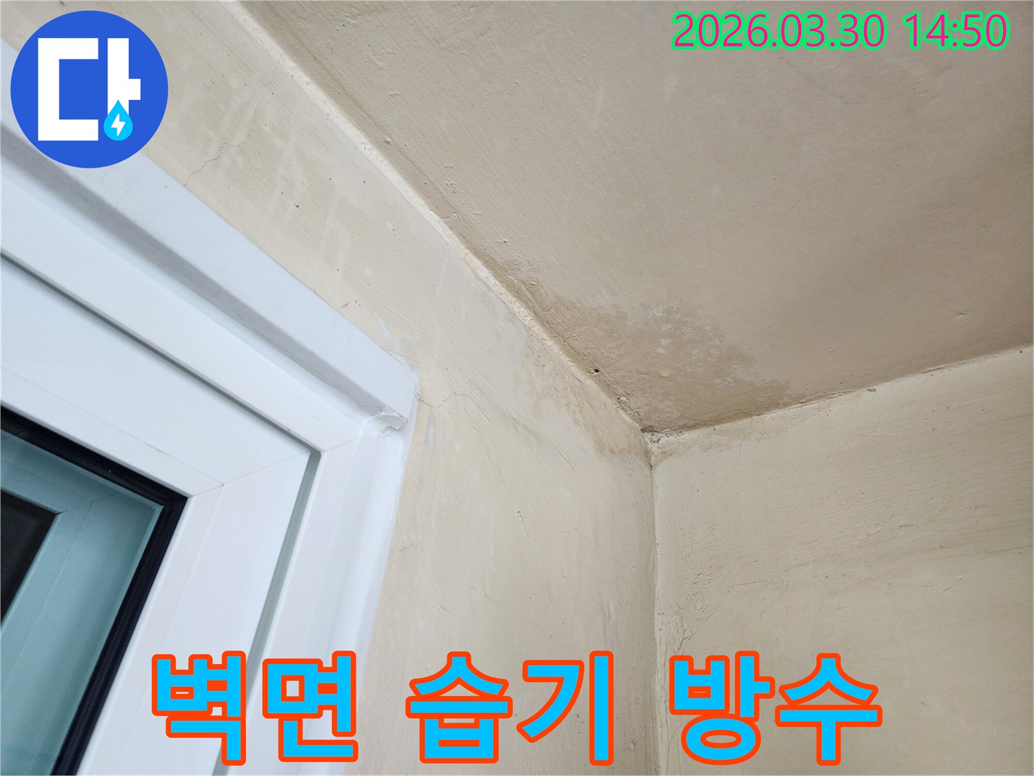 창문 옆-벽면과 천장 경계에-발생한 누수 흔적과-습기로 인한 변색을-보여주는 사진입니다