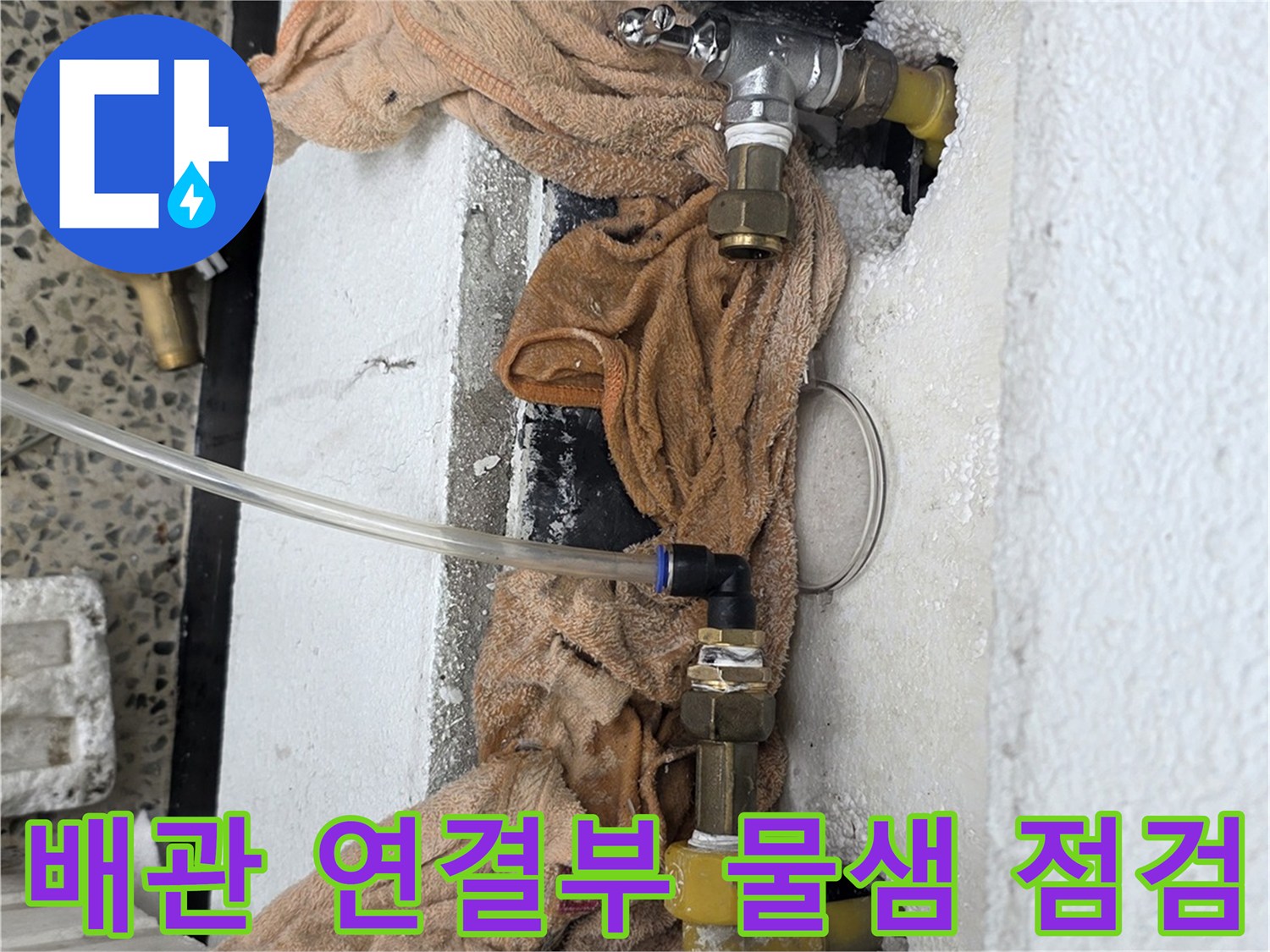 벽면 굴착 부위의 노후된 수도 배관과 밸브 연결 상태를 보여줍니다.