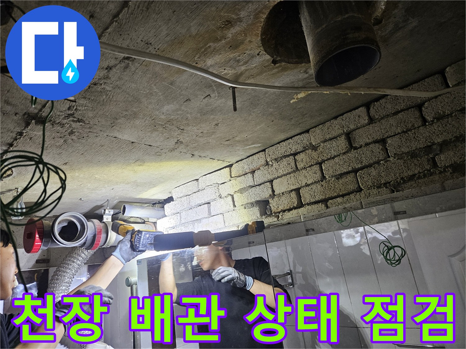 배관 주변의 습기를 확인하기 위해-손전등으로 정밀 진찰 중인 모습