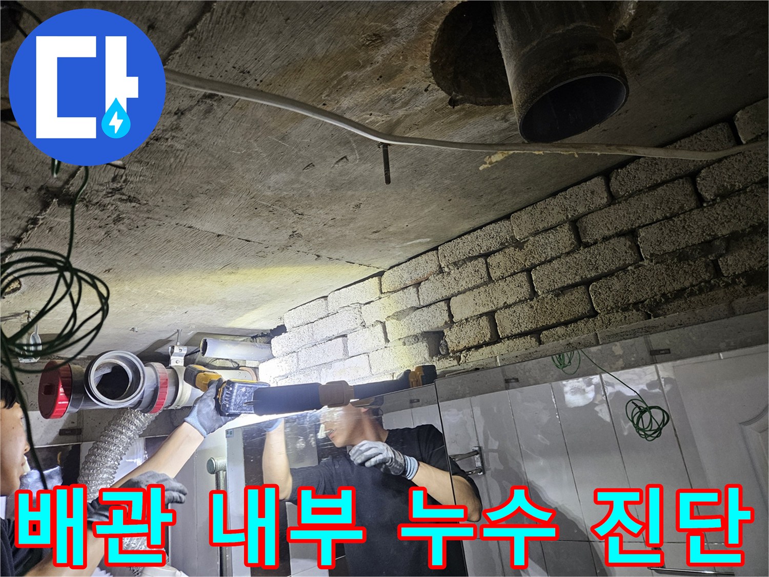 천장 배관의 파손 부위를 찾기 위해 조명을 비추는 엔지니어