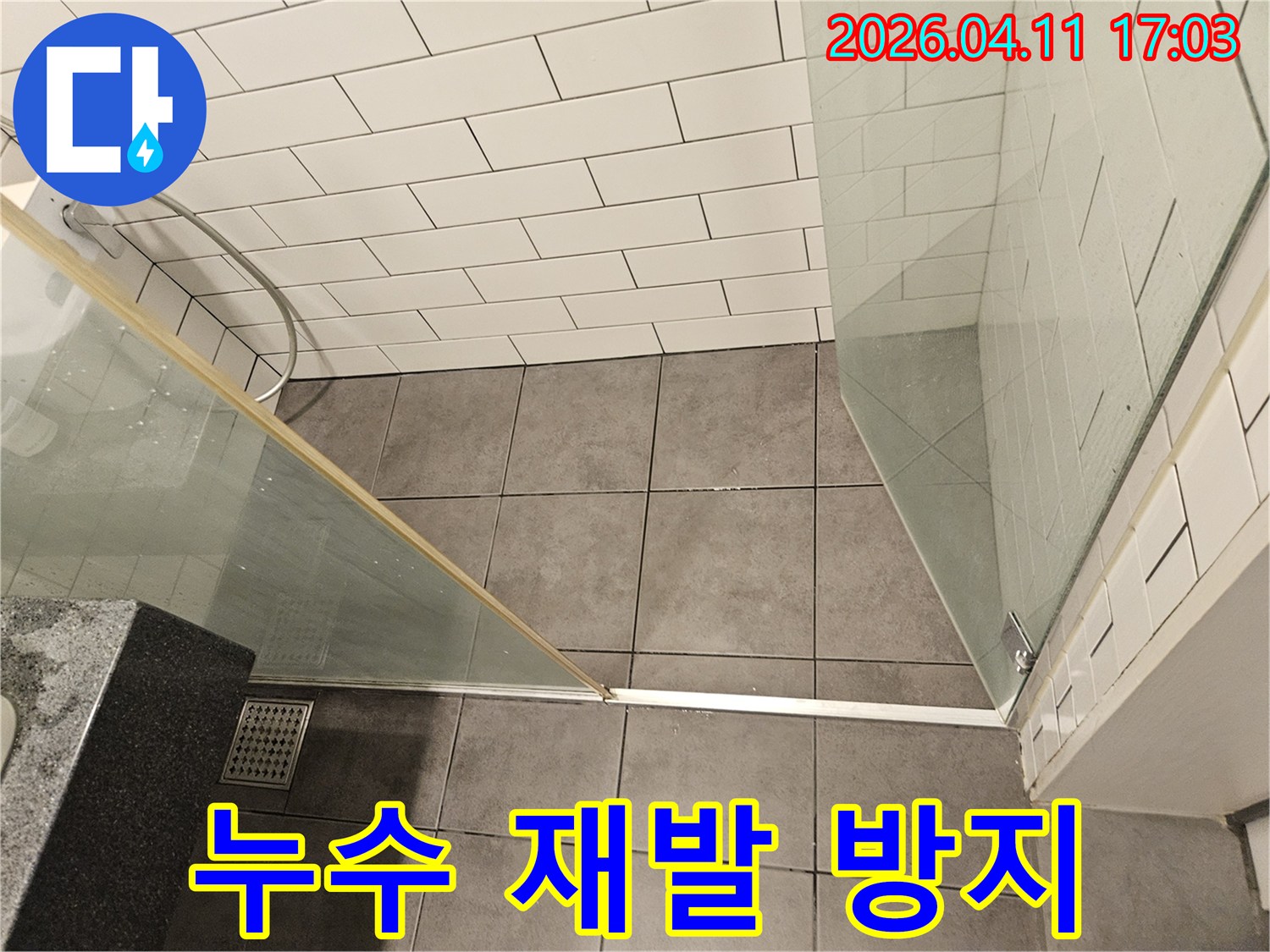 욕실 바닥 타일과-벽면 타일-샤워 부스 주변의-전반적인 상태를-꼼꼼히 점검하며-누수 재발 방지 대책을-고려하는-현장 사진입니다.