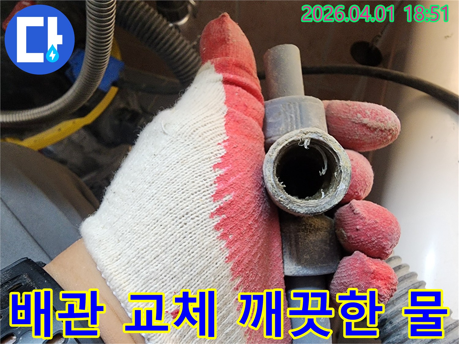 작업용 장갑을 낀 손으로-오래되어 부식된 배관을 들고-새 배관 교체로 깨끗한 물 사용을 설명하는 모습