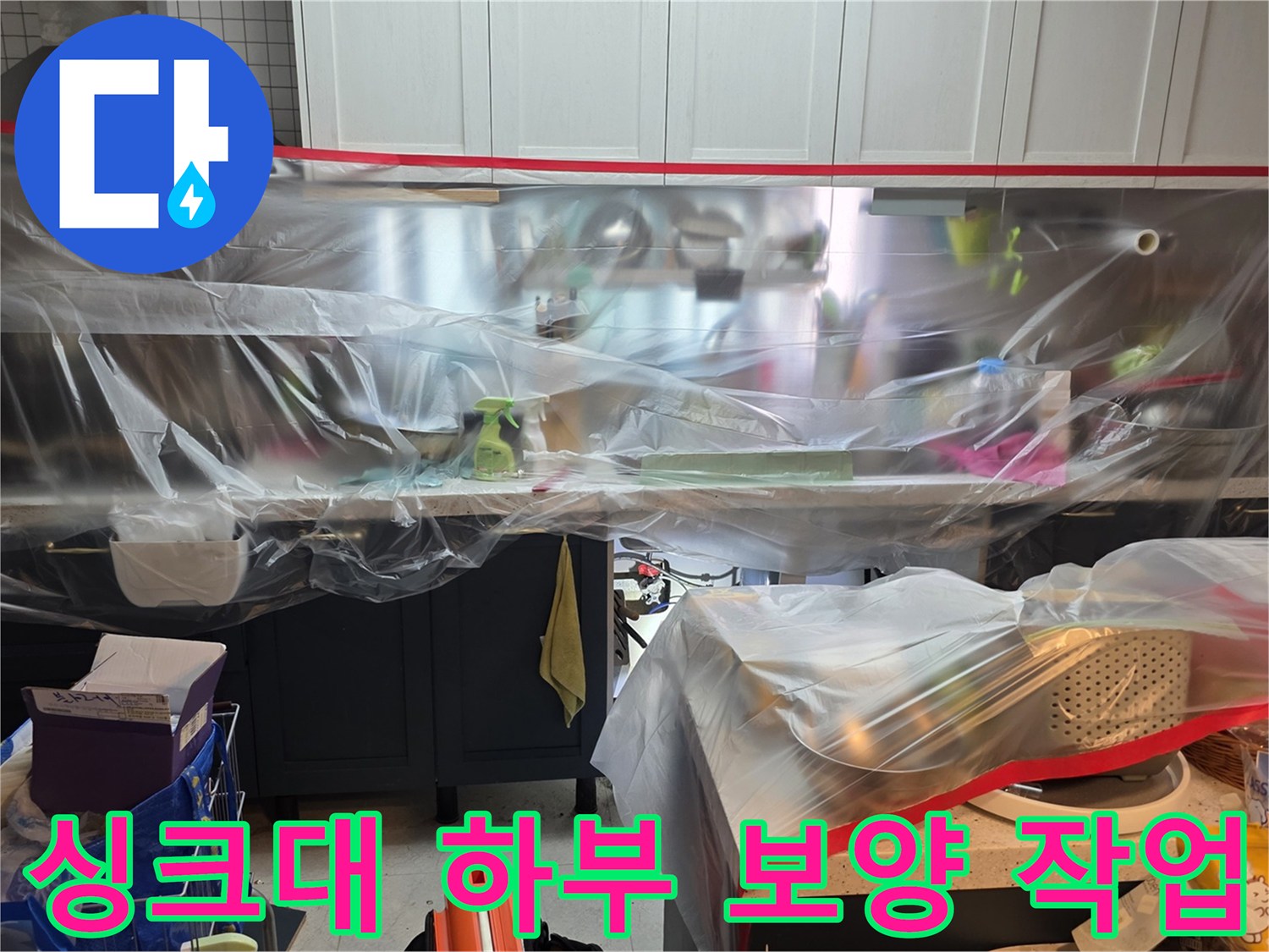 싱크대 하부장 주변을 비닐로 꼼꼼하게 감싼 보양 상태입니다.