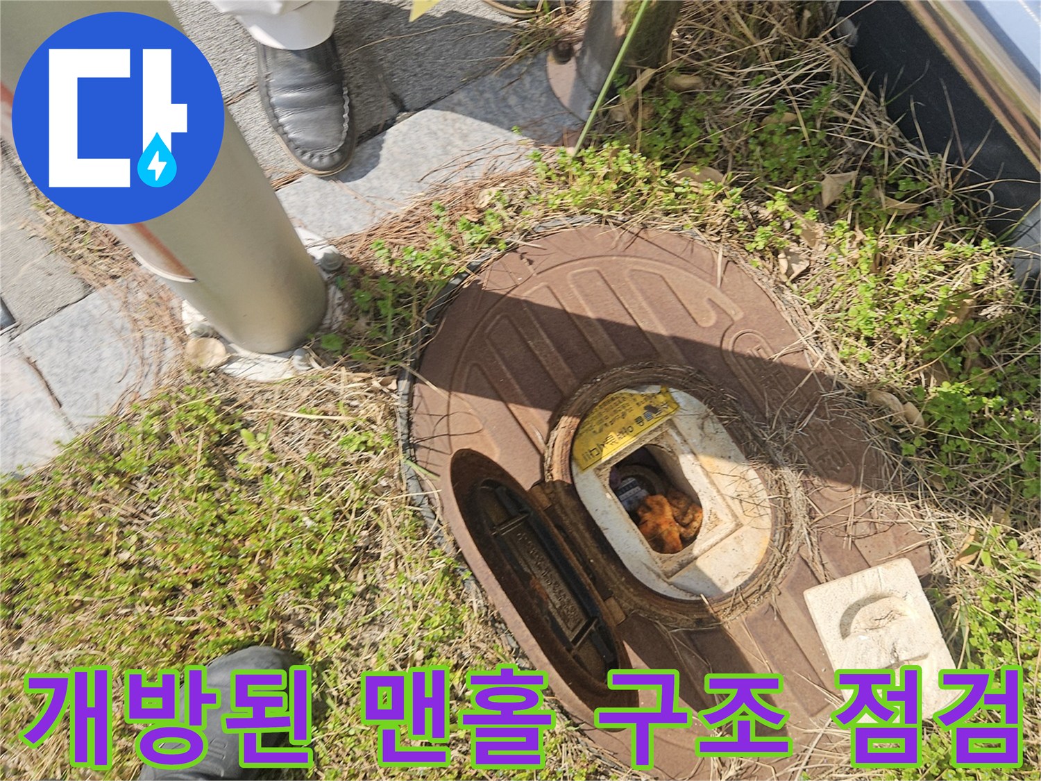 맨홀 내부의 배수 통로와 주변 지면을 가까이서 촬영한 사진입니다.