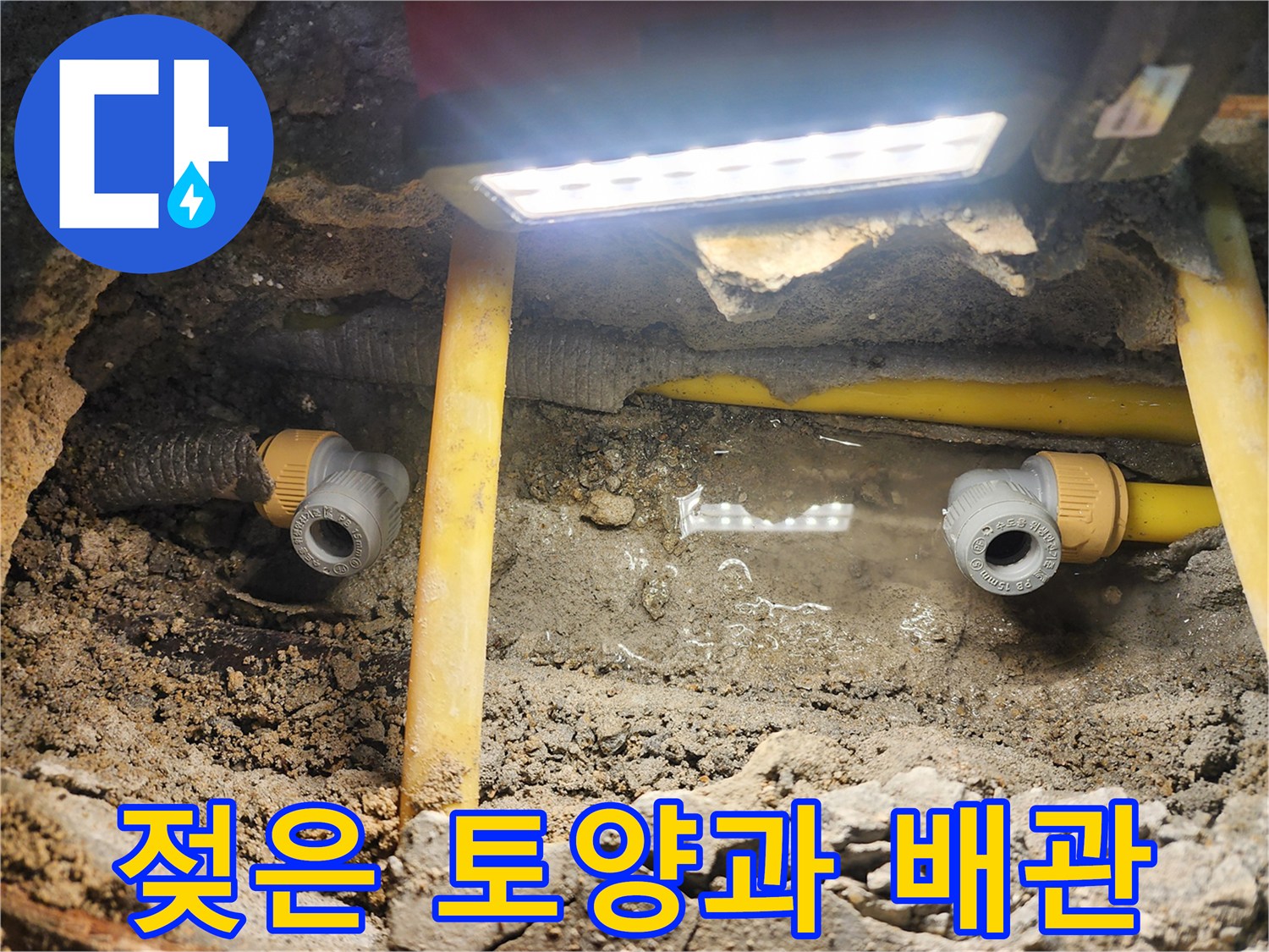 신도한동 아파트-수도 배관 주변의 젖은 흙과 노란색 관로 모습