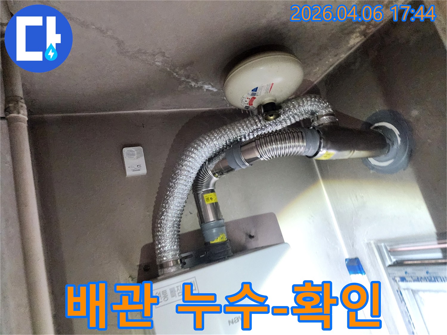 이 사진은 보일러실 천장에 생긴 물자국을 통해-배관 누수 여부를 확인하는 현장의 모습을 담고 있습니다