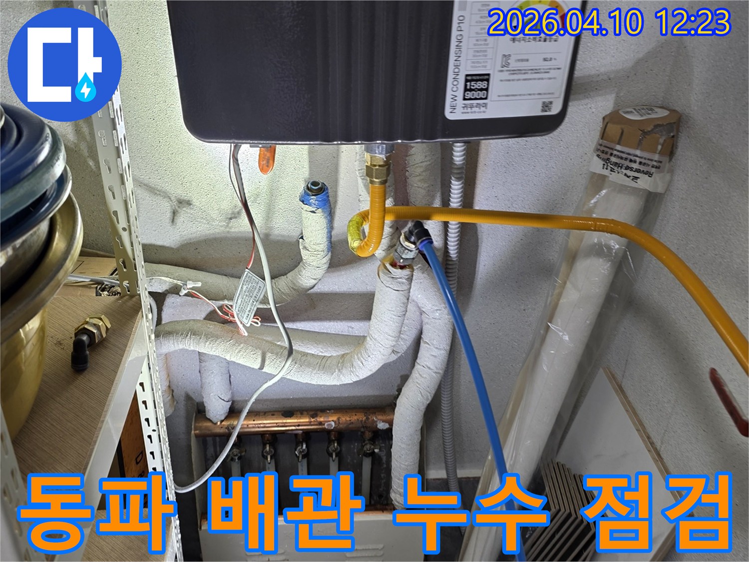 단열재로-감싸인-배관과-녹슨-분배기가-보이는-현장에서-겨울철-동파로-인한-누수-여부를-점검하는-사진입니다