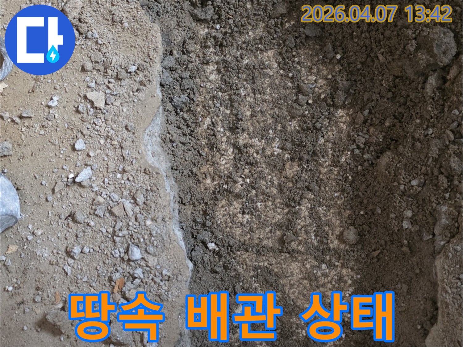 누수-탐지-현장에서-땅을-파내어-드러난-배관-주변의-습기-머금은-흙을-보여주는-이미지