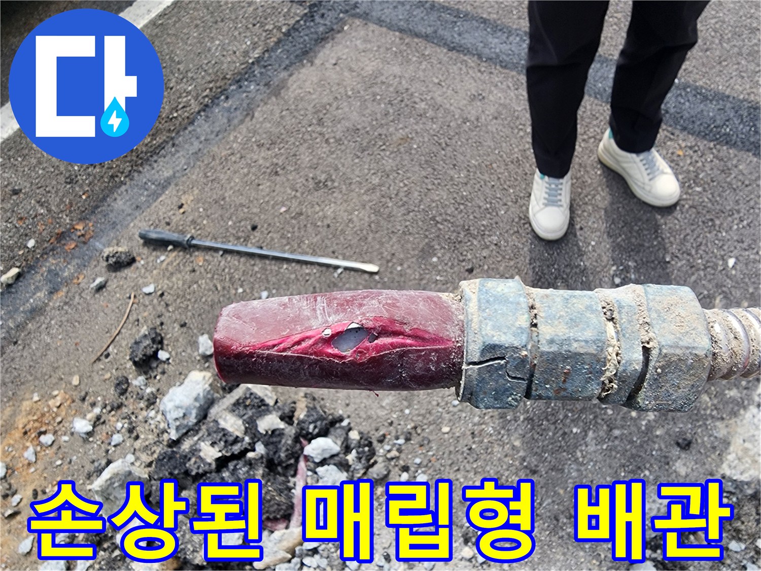 누수 지점 노출-아스팔트 아래 파손된 붉은색 급수관