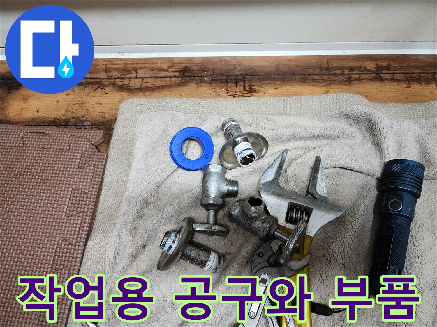 수도 연결 부위 부품-공구와 손전등이 놓인 작업대