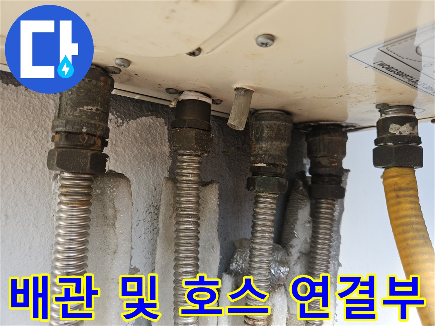 보일러 하단 배관-금속 관과 노란색 호스의 연결 상태