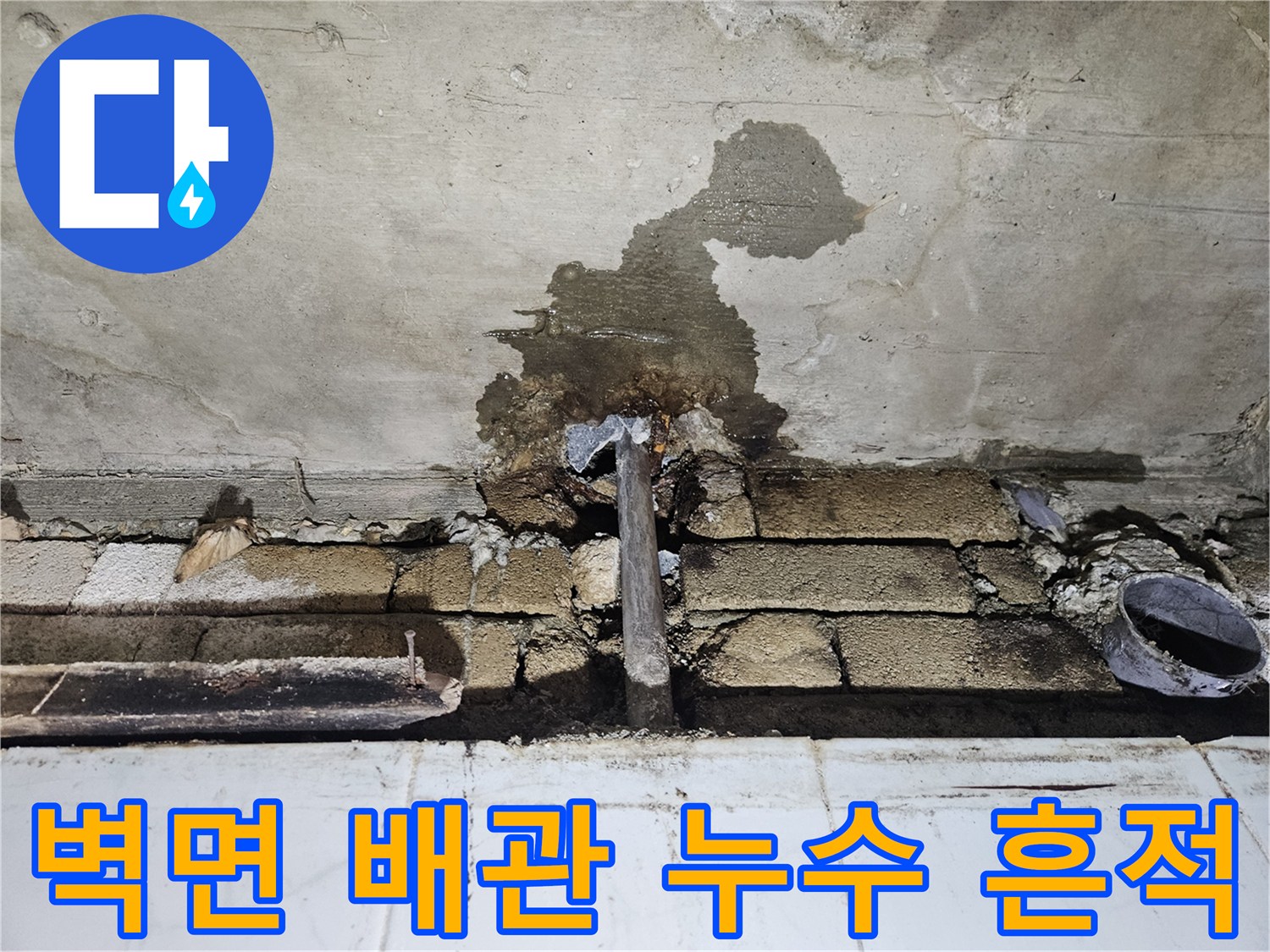 화장실 벽면-젖어있는 콘크리트와 노출된 배관 부위