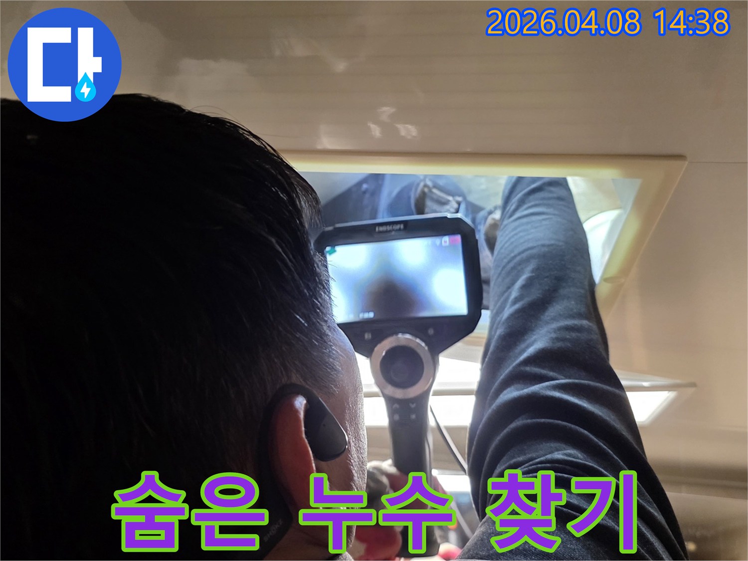 전문 누수 탐지사가 내시경 카메라를 이용해 숨겨진 배관의 누수 지점을 정밀하게 관찰하는 모습