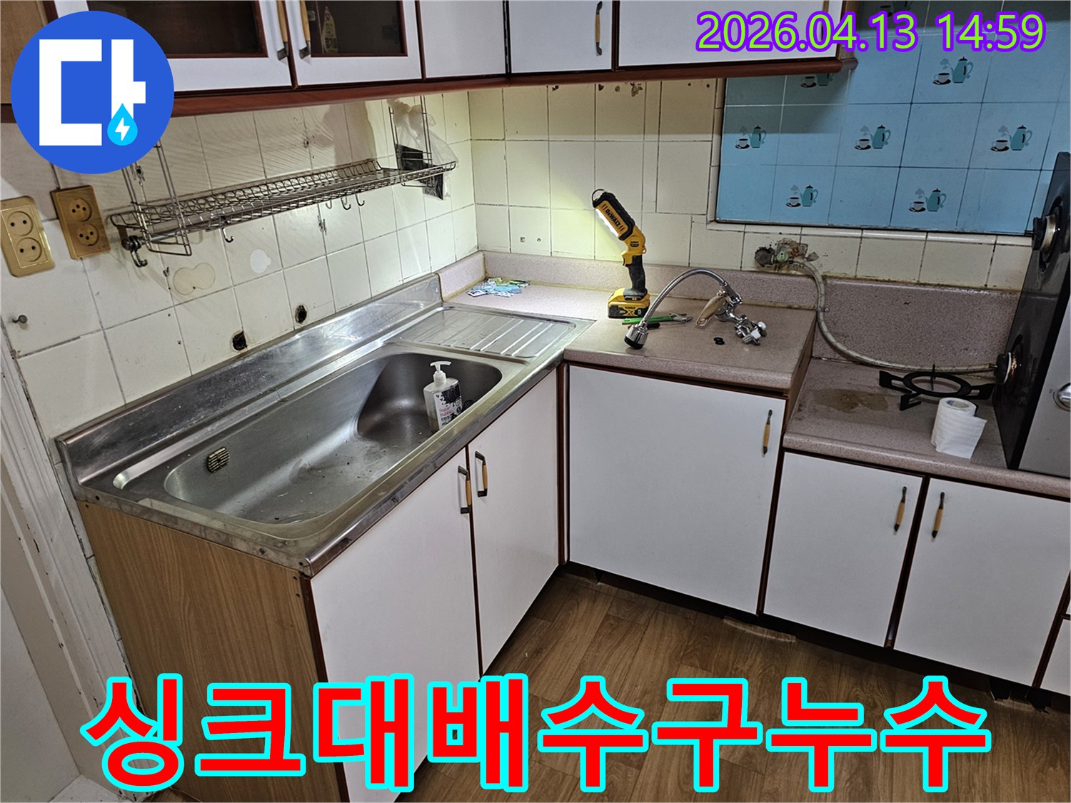 싱크대 배수구 주변에서 발생한 누수를 확인하기 위해-작업등을 비춰 정밀하게 점검하는 현장입니다