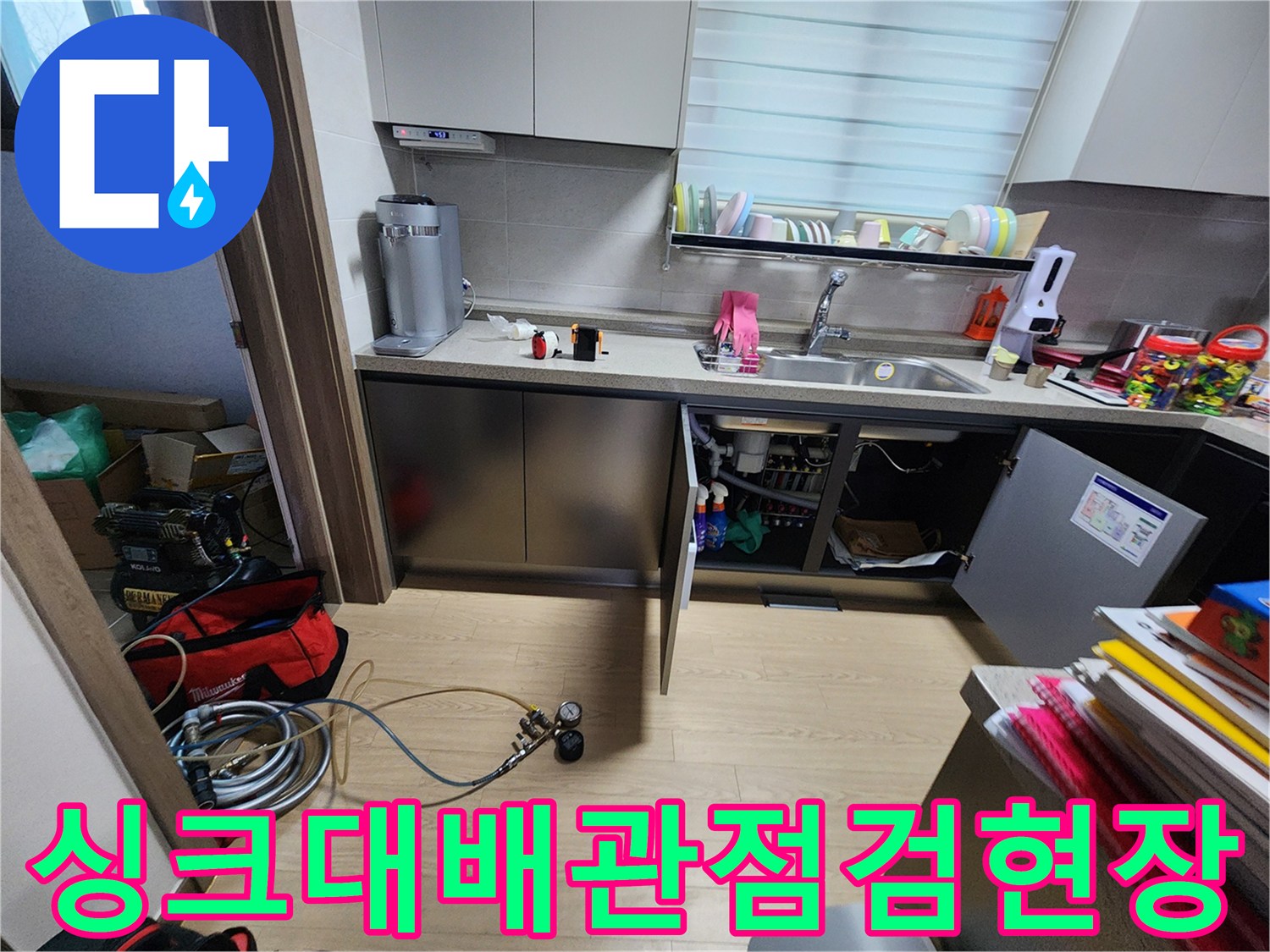 싱크대 하부 분배기 근처의 가스 탐지용 호스와 측정 장비 모습