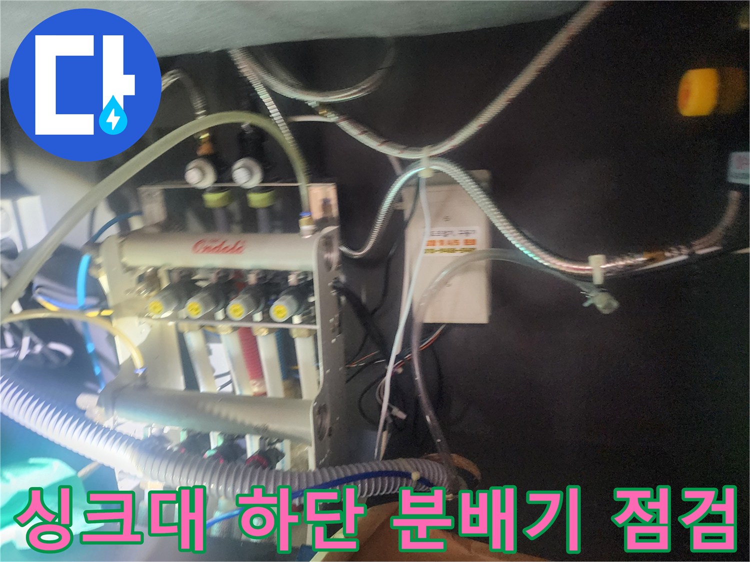 주방 싱크대 아래쪽-복잡한 배관과 가스 탐지용 호스가 연결된 모습