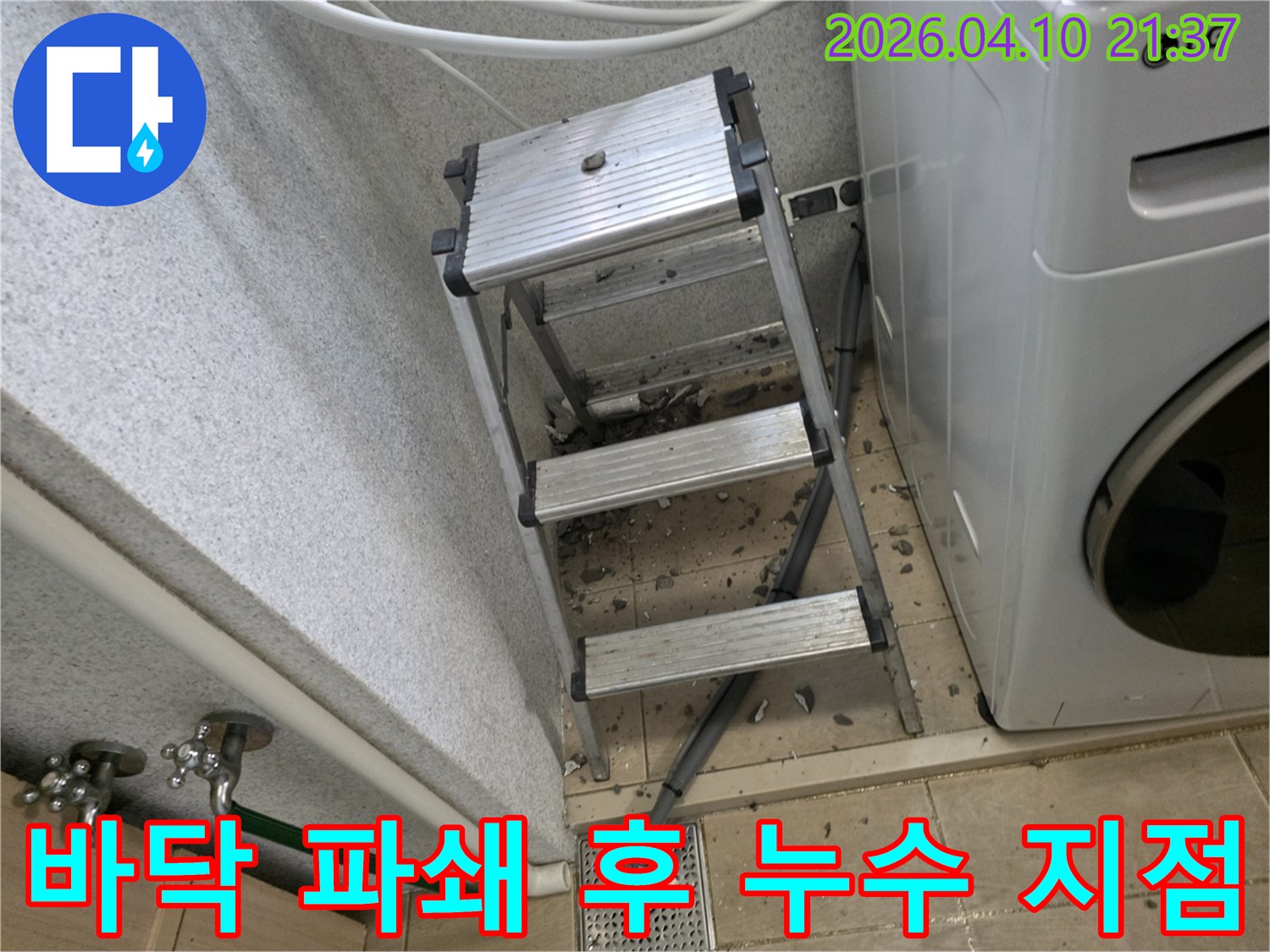세탁실 바닥을 파쇄하여 누수 원인을 찾고 있는 공사 현장입니다-안전을 위한 발판과 파쇄된 잔해들이 보입니다.