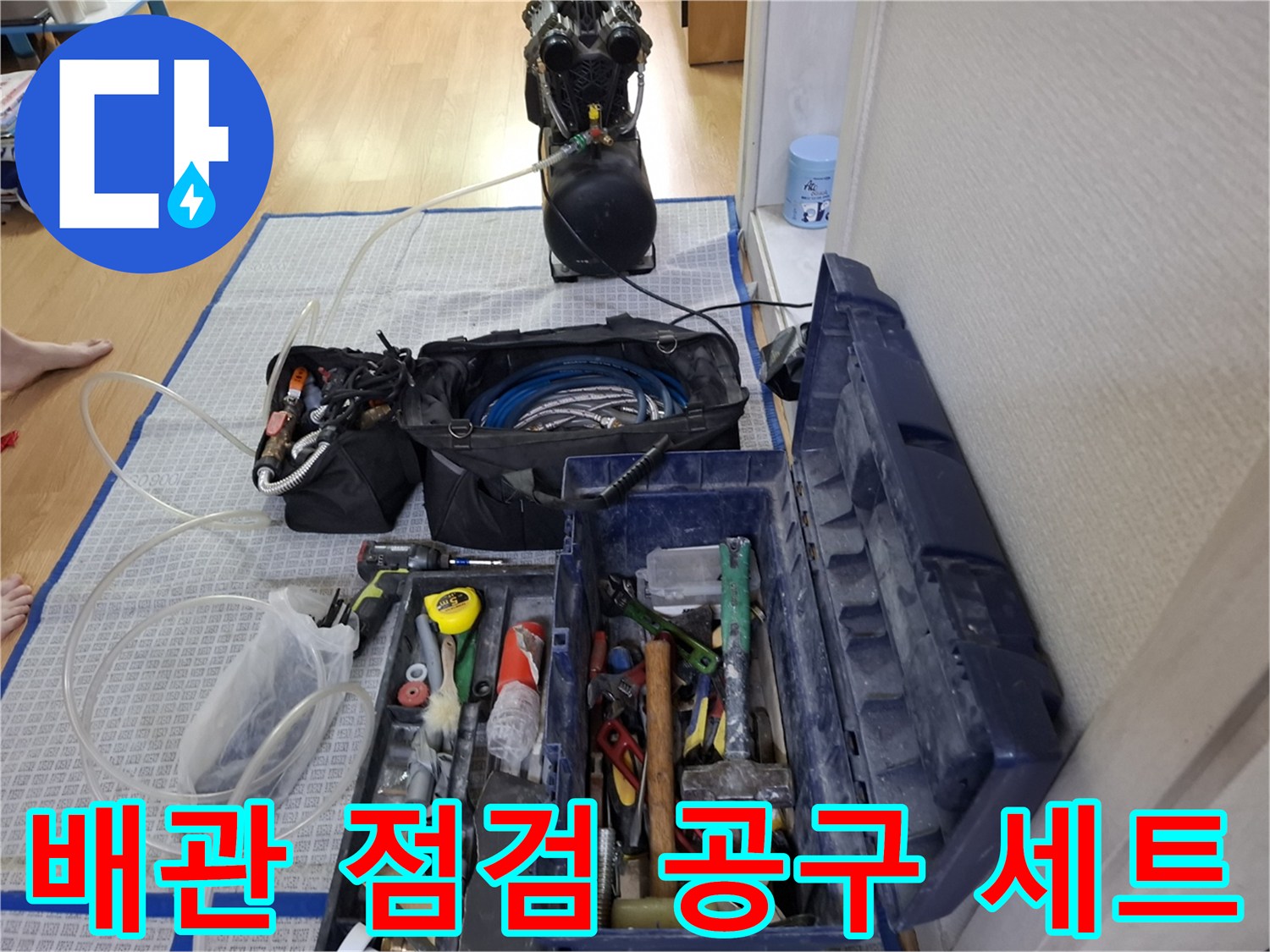 바닥에 펼쳐진 누수 탐지 호스와 수리용 전문 도구함-작업 준비