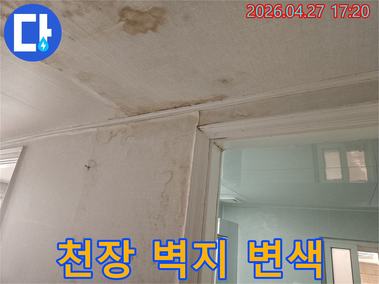 이 이미지는-천장과-벽지-경계면에-발생한-누수로-인해-벽지가-심하게-변색되고-손상된-모습을-보여주며-이는-상층부-배관-문제로-인한-누수-피해입니다
