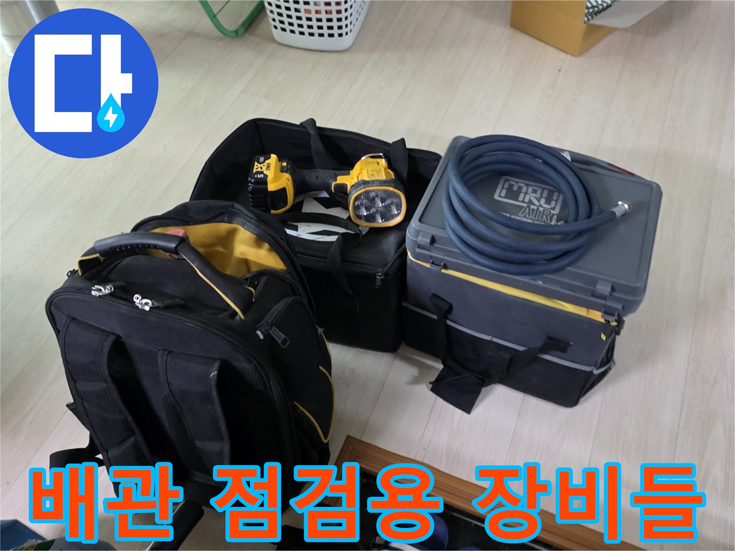 현장에 준비된 공압 테스트기와 배관 점검을 위한 전문 라이트 및 가방