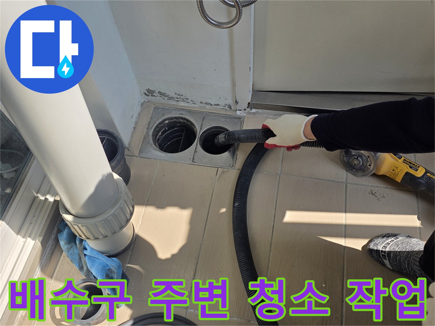 배수구 주변의 이물질을 진공청소기로 제거하는 모습