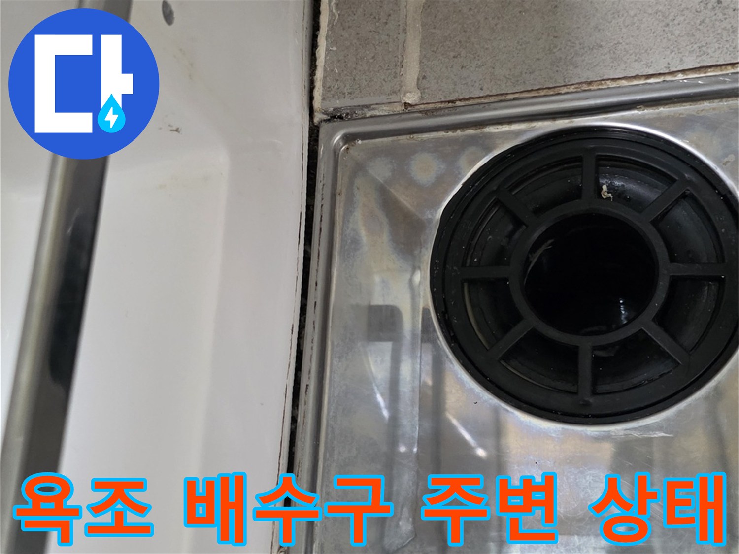 욕조 배수구 부근의 타일과 마감재 상태를 보여주는 사진